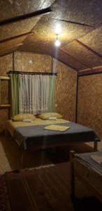 a bedroom with a bed in a room with a curtain at Ethno Village Koljeno Camp & Bungalows in Andrijevica