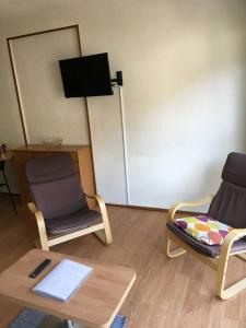 a room with two chairs and a table and a tv at La Mongie, apt 30m2 centre station in Bagnères-de-Bigorre