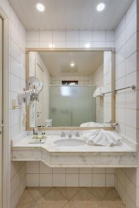 baño con lavabo grande y espejo en Kuster Hotel, en Guarapuava