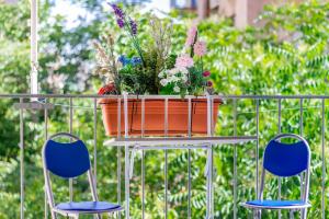 um vaso de flores sentado numa mesa com duas cadeiras em Travel Resort em Atenas