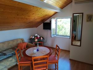 a living room with a table and chairs and a couch at Captain Apartments in Vinišće