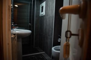 a small bathroom with a sink and a toilet at Saint Michel Chalets in Al Arz