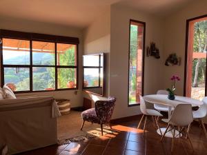 a living room with a table and chairs and windows at La Mandorla Salata in Capoliveri
