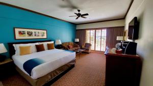 a bedroom with a large bed and a blue wall at Harbor View Inn in Santa Barbara