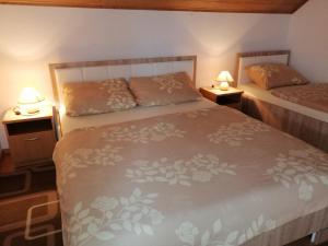 een slaapkamer met 2 bedden en 2 lampen op tafels bij House Mihaela&nina in Seliste Dreznicko
