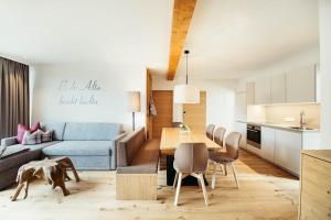 シュルンスにあるadler alpen apartmentsのリビングルーム、キッチン(ソファ、テーブル付)