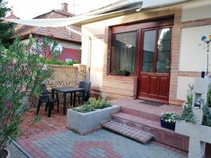 a patio with a table and chairs in front of a house at Kerékvár apartman Gyula in Gyula