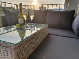 a couch and a table with wine glasses and a bottle at Wohnstation in Subingen