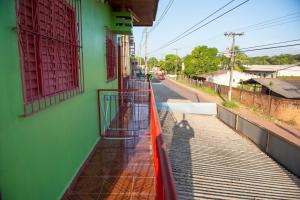 uma varanda de um edifício com um corrimão vermelho em Excelente Apartamento - Família Mangas Monteiro em Macapá