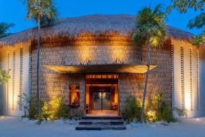 a resort with a thatched roof and palm trees at Hotel Ma'xanab Tulum in Tulum