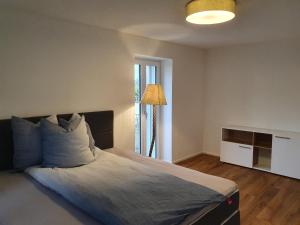 a bedroom with a large bed and a lamp at Wohnstation in Subingen