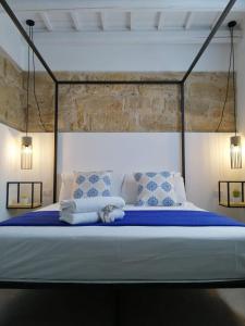 a bedroom with a large bed with blue sheets and pillows at B&B Sea Salt in Terrasini