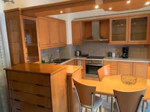 a kitchen with wooden cabinets and a table with chairs at Danai's Loft in Heraklio