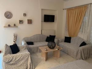 a living room with two couches and a table at Danai's Loft in Heraklio