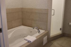 a bathroom with a tub with a towel on it at Holiday Inn Express Hotel & Suites El Dorado Hills, an IHG Hotel in El Dorado Hills