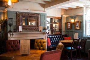 a restaurant with a fireplace and a table and chairs at Angel @ KingSt in Knutsford