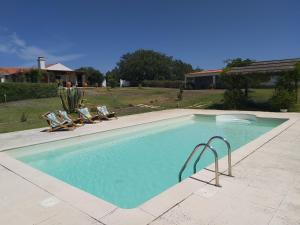 una piscina con 2 sillas de césped en Monte da Corte by Hi Alentejo, en Santiago do Cacém