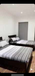 dos camas sentadas una al lado de la otra en una habitación en Spacious Shude Hill Apartment With Balcony, en Mánchester