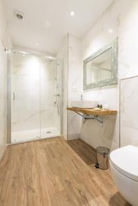 een badkamer met een douche, een toilet en een wastafel bij UBICACIÓN INMEJORABLE REFORMADO LUJO in Bilbao