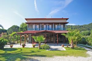 Una casa grande con palmeras al frente. en Itamos Migdanis House, en Vourvourou