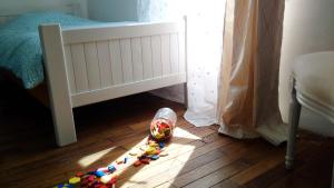 Dormitorio infantil con cuna y juguete en el suelo en LE MASSITROU - chambre d'hôte - Table d'hôte, en Nedde