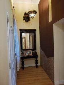 a hallway with a mirror and a table and a chandelier at Apartamento Cruz Vieja in Jerez de la Frontera