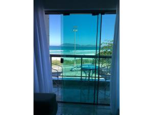 a room with a view of the ocean and a balcony at FORTE DA PRAIA 2 in Cabo Frio