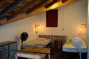 a room with two beds and a table at Hostel De Boca en Boca in Granada