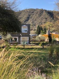 ein Haus mit einem Zaun und einem Berg im Hintergrund in der Unterkunft LA MACARENA in La Rioja