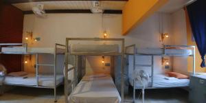 a bed room with two beds and a desk at Hostel De Boca en Boca in Granada