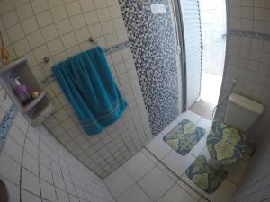 uma casa de banho com um chuveiro e uma toalha azul em Casas Maragogi 2 em Maragogi