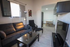 sala de estar con sofá y mesa en Apartamentos Cáceres Turístico en Cáceres