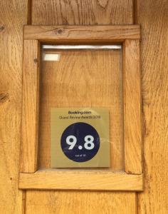 ein Schild an einer Holztür mit einer Uhr drauf in der Unterkunft Oak House Farm in Edenbridge