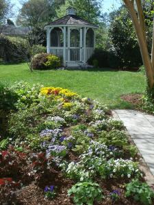 a gazebo in the middle of a garden with flowers at Newport House Bed & Breakfast in Williamsburg