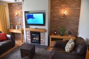 ein Wohnzimmer mit einem Kamin und einem TV in der Unterkunft ADAIR HOUSE in Ballymena
