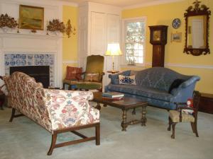 uma sala de estar com um sofá, cadeiras e uma mesa em Newport House Bed & Breakfast em Williamsburg