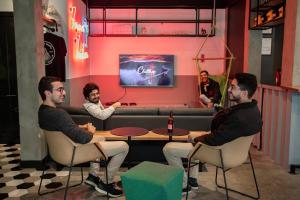 a group of men sitting around a table in a bar at Innbox - Centro in Florianópolis