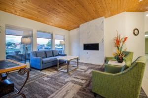 a living room with a couch and chairs and a tv at Baymont by Wyndham Tri-Cities/Kennewick WA in Kennewick