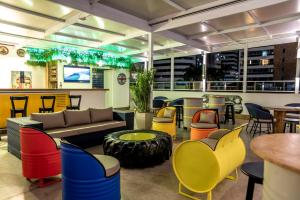 a bar with colorful chairs and a couch and tables at Hotel Villa Smart in Fortaleza