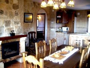 een keuken met een eettafel en een open haard bij Refugio La Covatilla I,II,III y IV in La Hoya