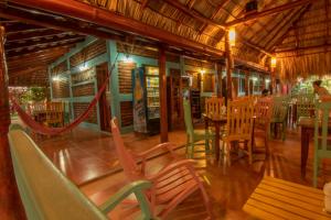 a restaurant with wooden chairs and tables and a bench at Club Surf Popoyo in Popoyo +66 photos