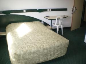 a hotel room with a bed and a desk and a table at Good Night Hotel in Arques