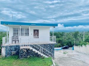 a small house with a blue roof on a hill at The Hill Inn at Arecibo 681 Ocean Drive in Arecibo