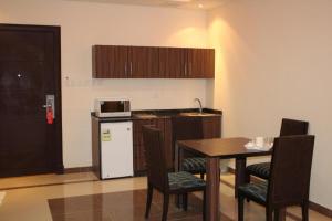 a small kitchen with a table and a refrigerator at Capital residence in Riyadh