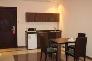 een kleine keuken met een tafel en een koelkast bij Capital residence in Riyad