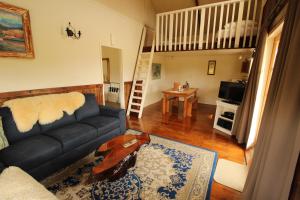 sala de estar con sofá y mesa en Waipoua Lodge, en Donnellys Crossing