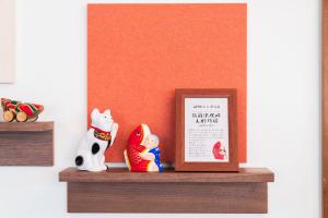 a shelf with a picture and some figurines on it at Vessel Hotel Kanda Kitakyushu Airport in Kanda