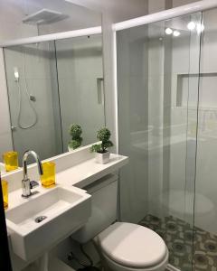 y baño con aseo, lavabo y ducha. en Lindo Apartamento em Arraial, en Arraial do Cabo