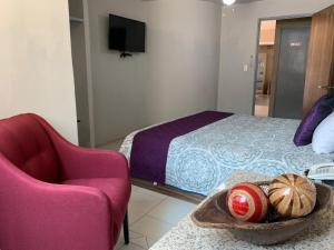 1 dormitorio con 1 cama, 1 silla y 1 mesa en Hotel FG en León