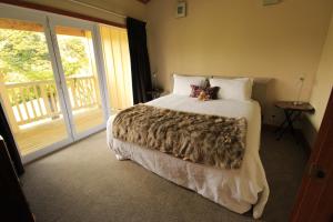 ein Schlafzimmer mit einem Bett mit zwei ausgestopften Tieren darauf in der Unterkunft Waipoua Lodge in Donnellys Crossing